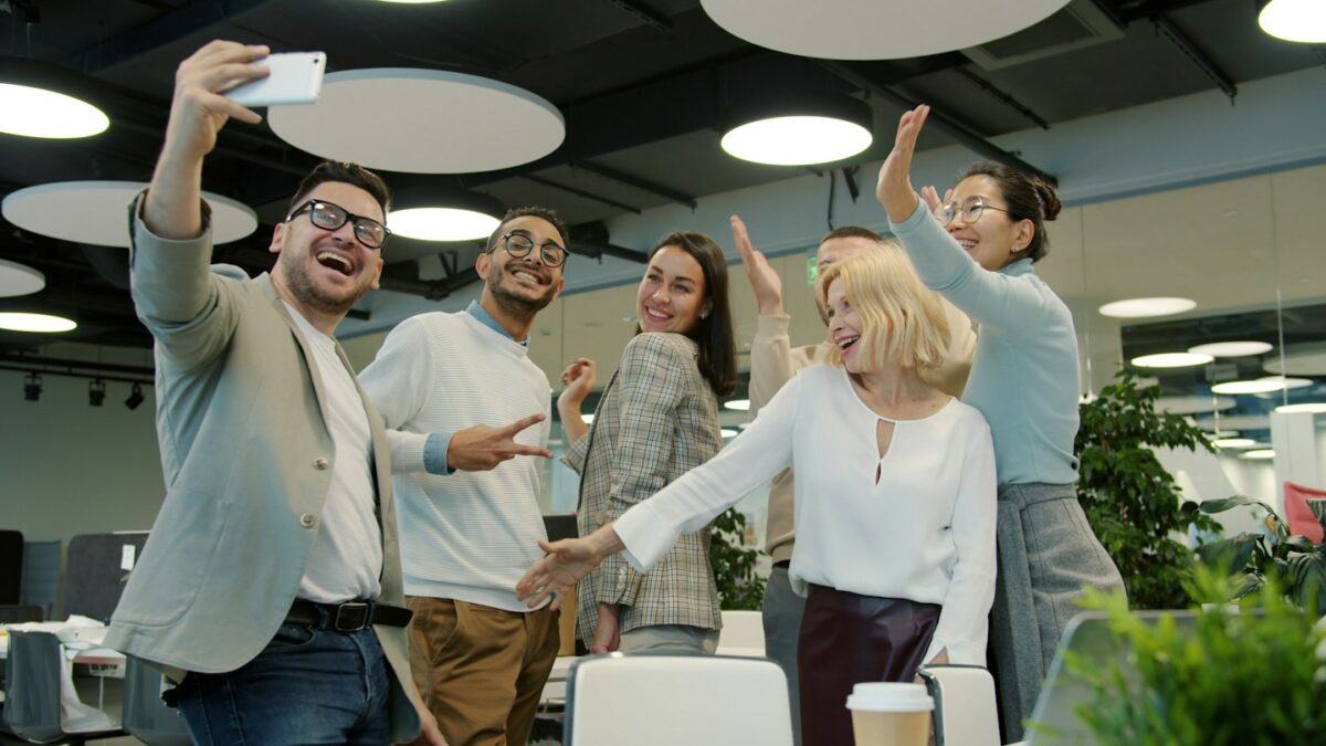 Diverse group of colleagues taking a selfie in office