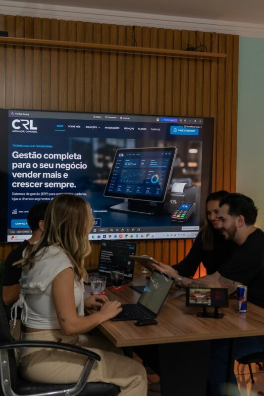 Colleagues collaborating around a table with a large screen display