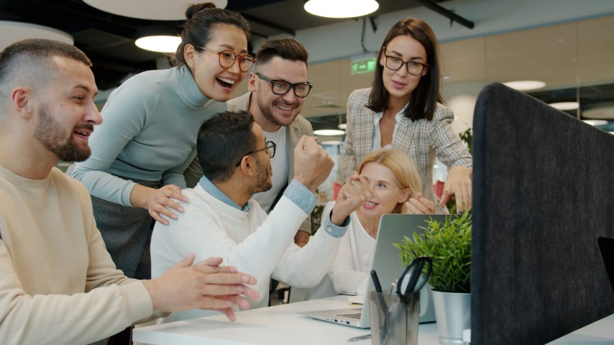 Diverse team celebrating success at office desk