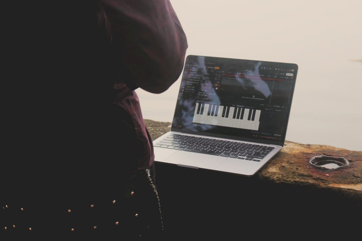 Music website homepage displayed on a laptop in a creative studio