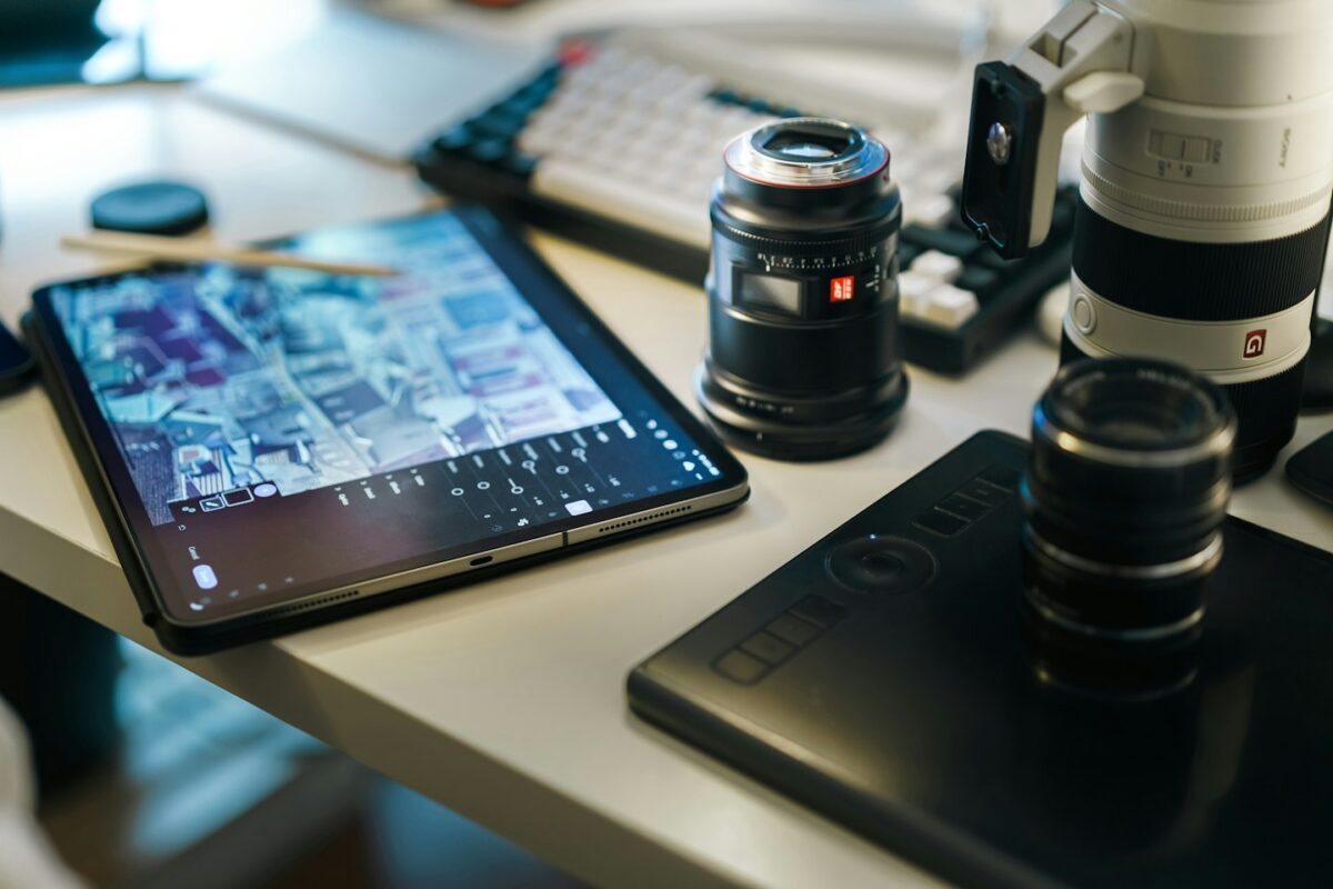 A tablet computer sitting on top of a table next to a camera