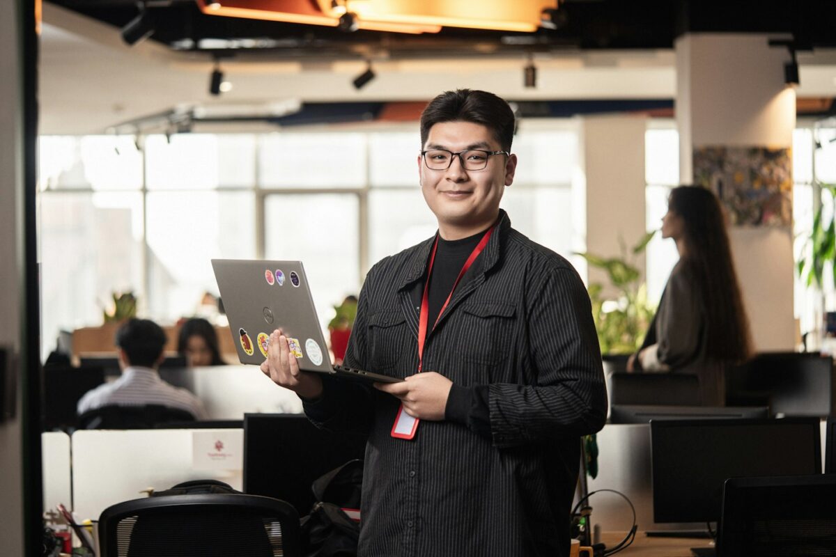 Man holding a laptop in a modern office setting