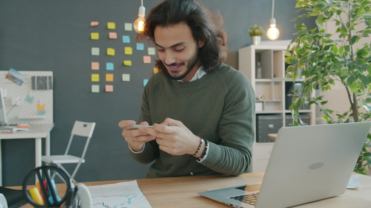 Man smiling while looking at his phone