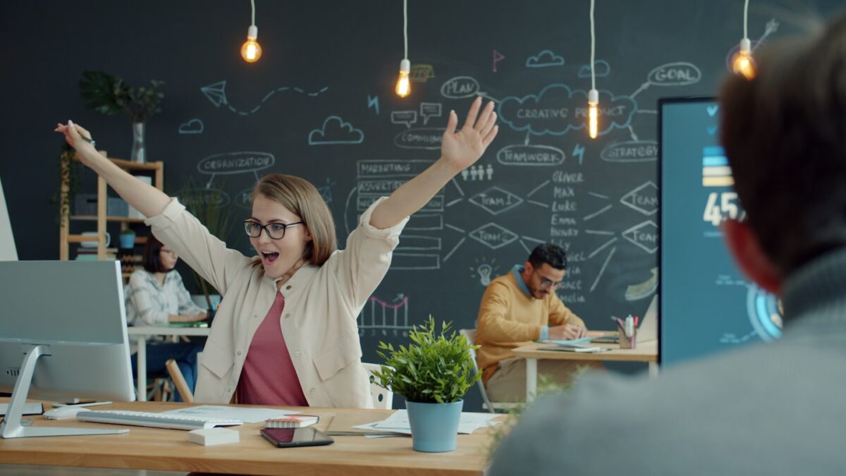Woman celebrating success at her office desk
